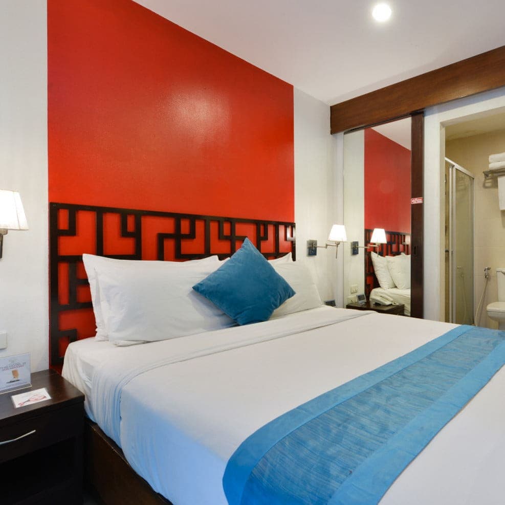 A king room at Arawana Express Chinatown, behind a red fretwork headboard wall